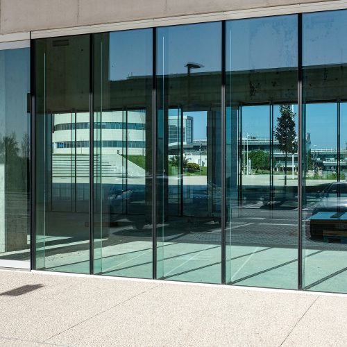 A vertical shot of the transparent doors of a commercial building